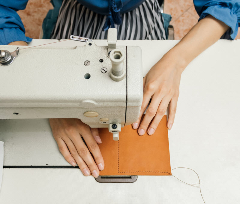 Woman sewing a leather product