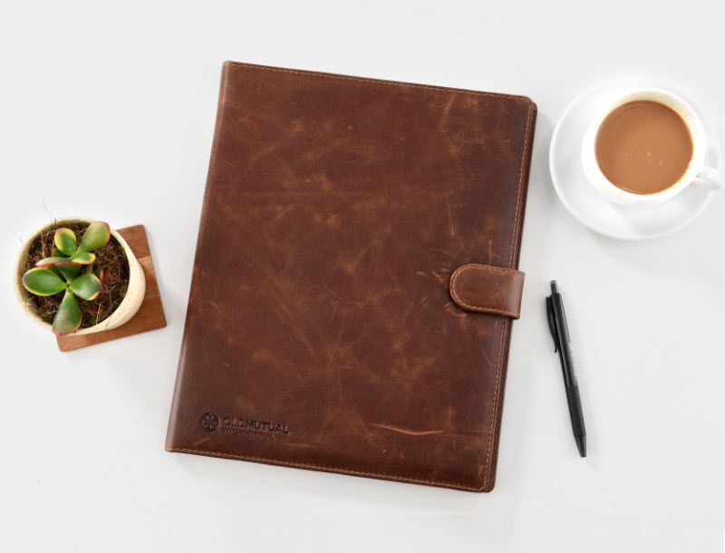 Leather notebook on the table with pen and a cup of coffee