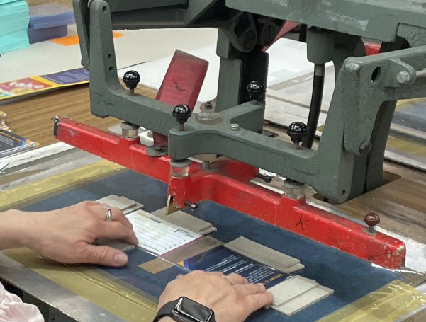 Worker cutting a card using a machine