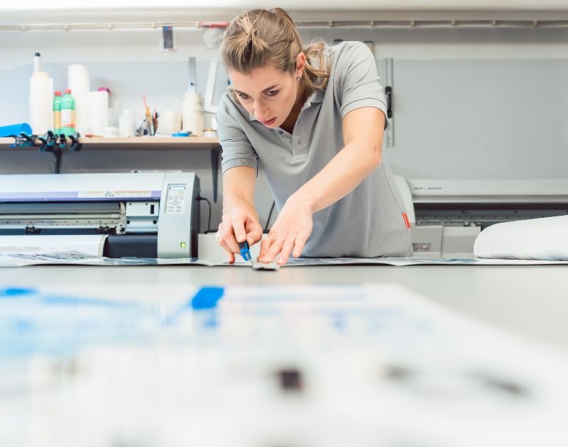 Acme Preston - Enhance your image Woman cutting a vinyl banner